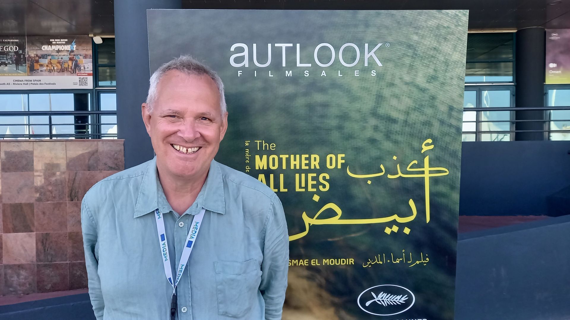 Thom Palmen in front of The Mother of all Lies poster Cannes Film Festival 2023