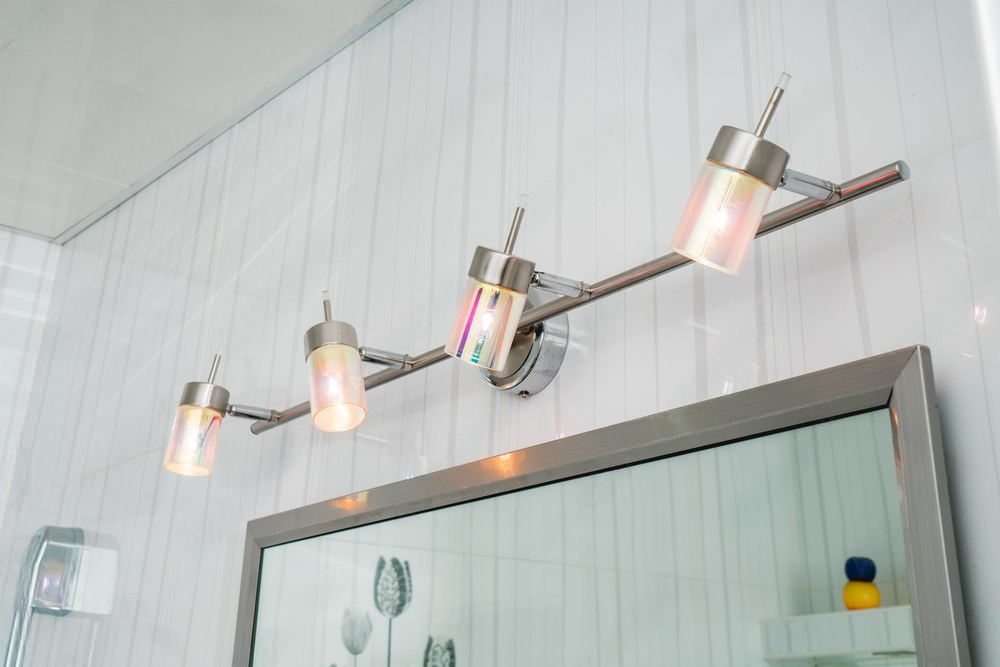 a bathroom with a vanity light and a mirror .