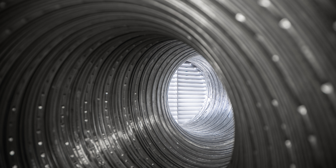 A black and white photo of a metal pipe with a hole in the middle.