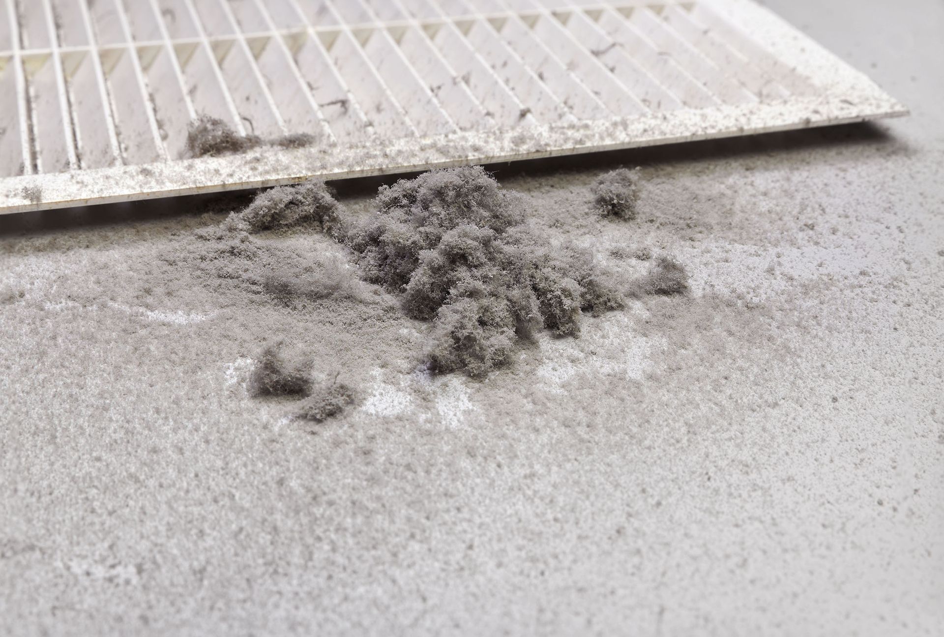 A close up of a dirty air filter on the floor.