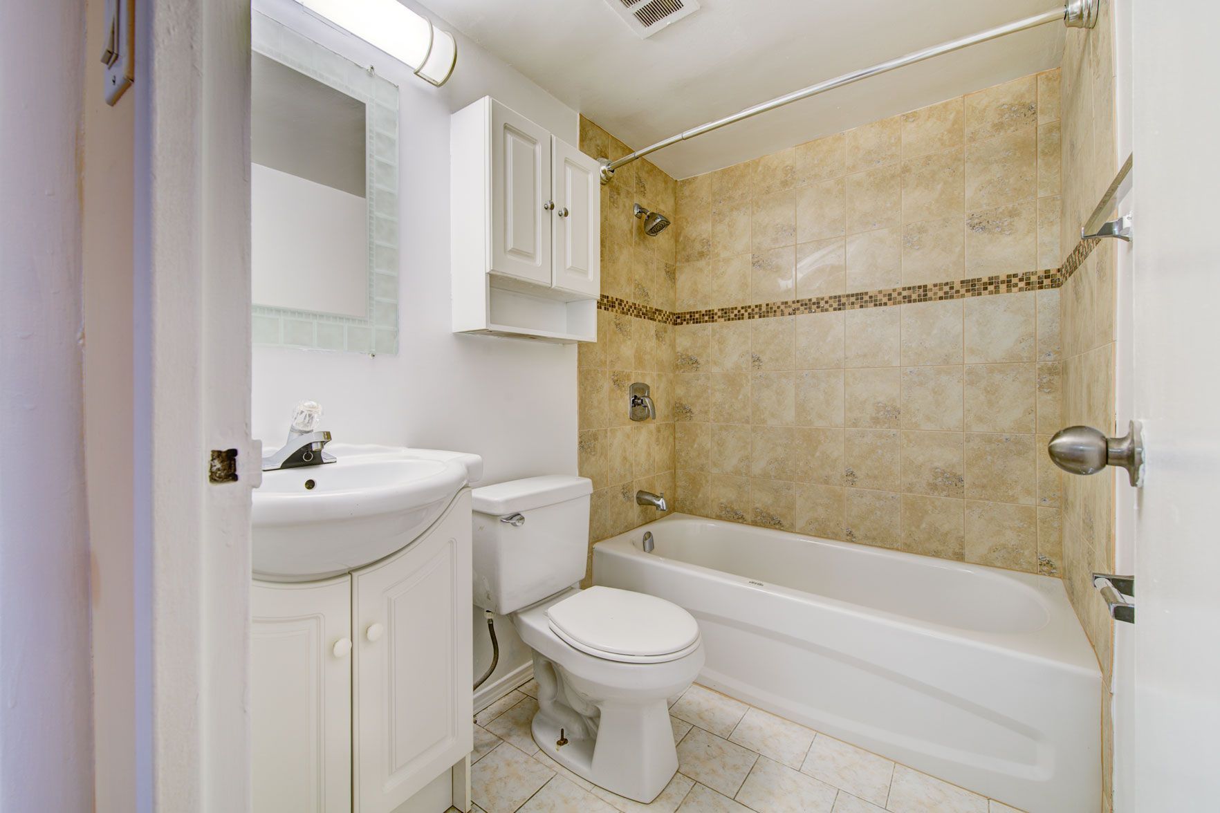 A bathroom with a toilet , sink and bathtub.