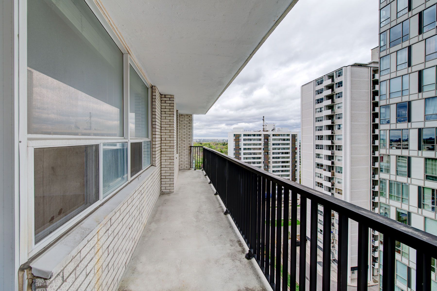 A balcony with a railing and a view of a city.
