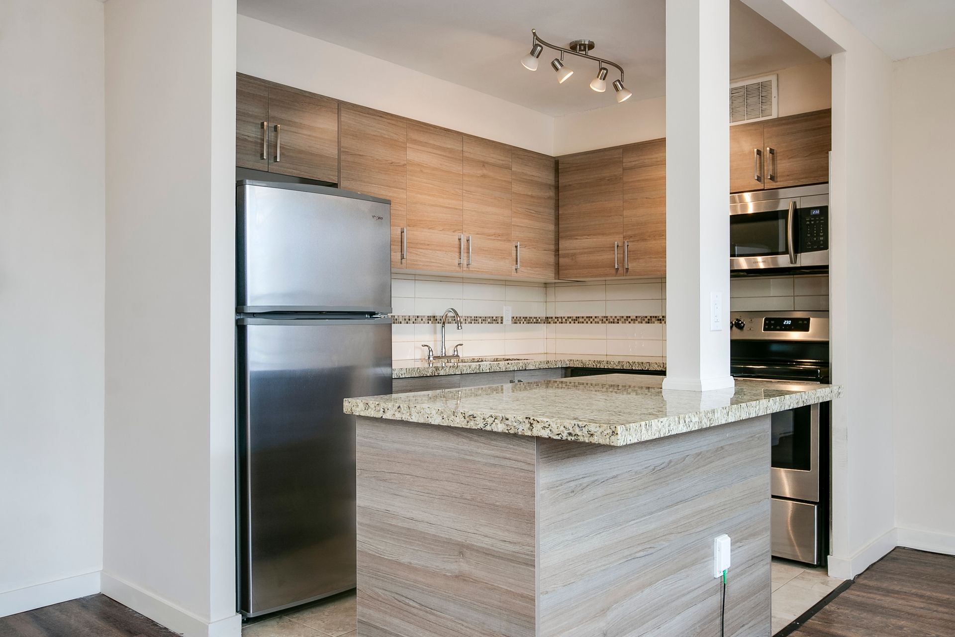 A kitchen with stainless steel appliances and wooden cabinets