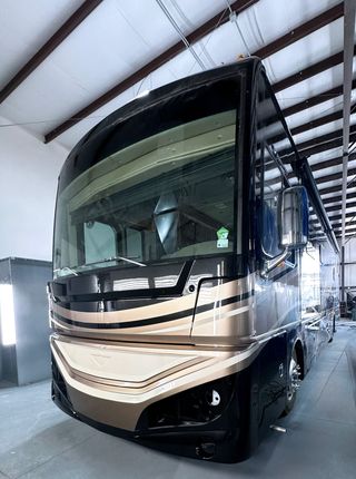 A large rv is parked in a garage.