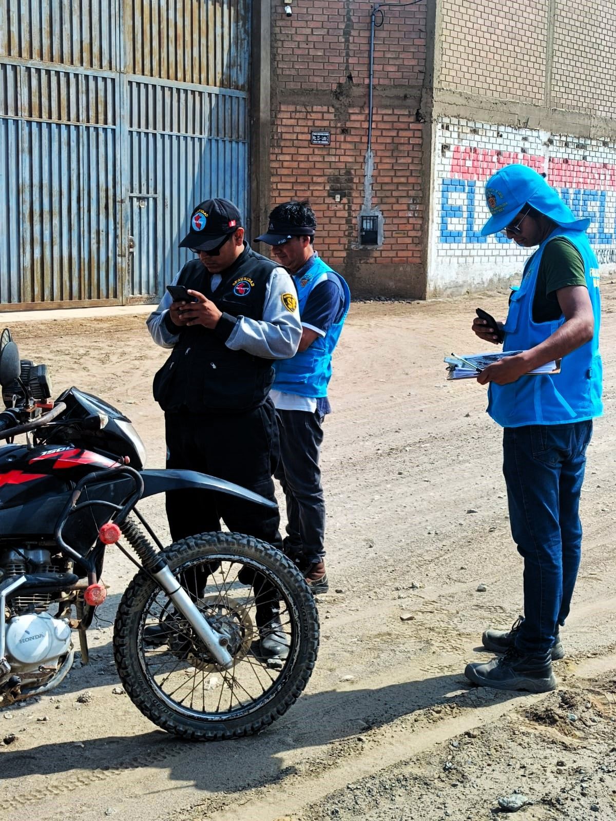 Tres personas examinando una motocicleta. 
