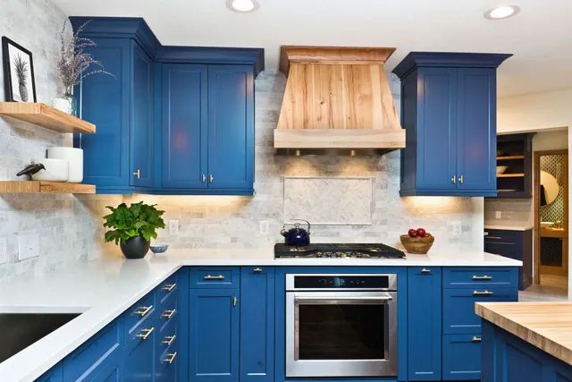 a kitchen with blue cabinets and stainless steel appliances