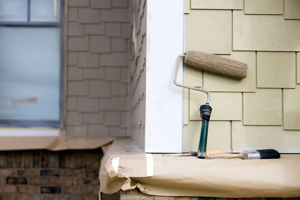 a paint roller is being used to paint the side of a house