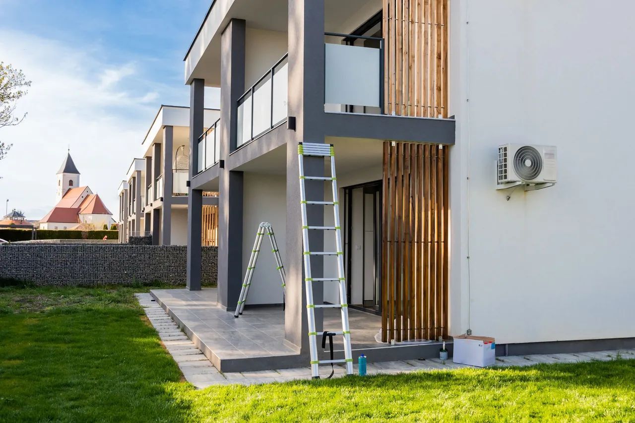 a ladder is sitting in front of a building that is being painted