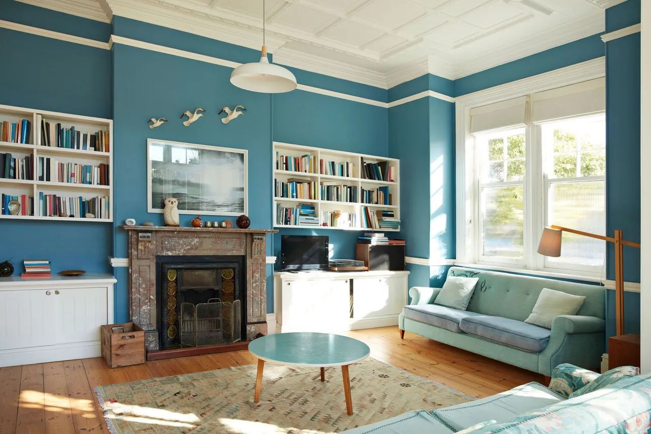 a living room with blue walls and a fireplace