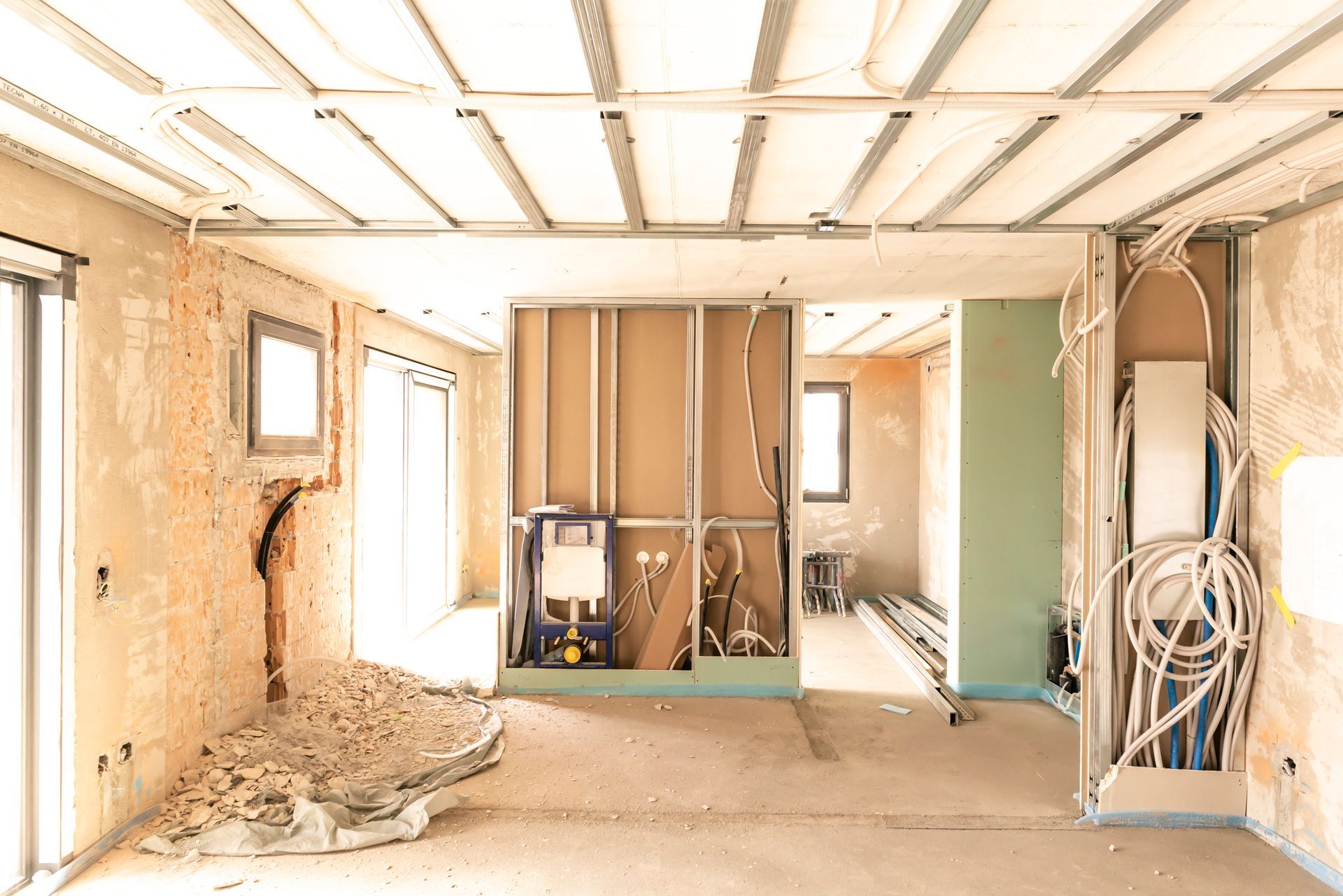 Interior of a room under construction, with exposed framework, wires, and drywall.