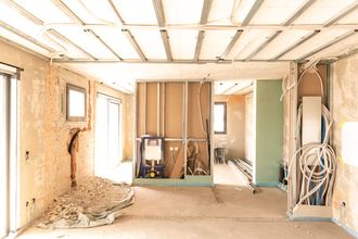 Interior of a room under construction, with exposed framework, wires, and drywall.