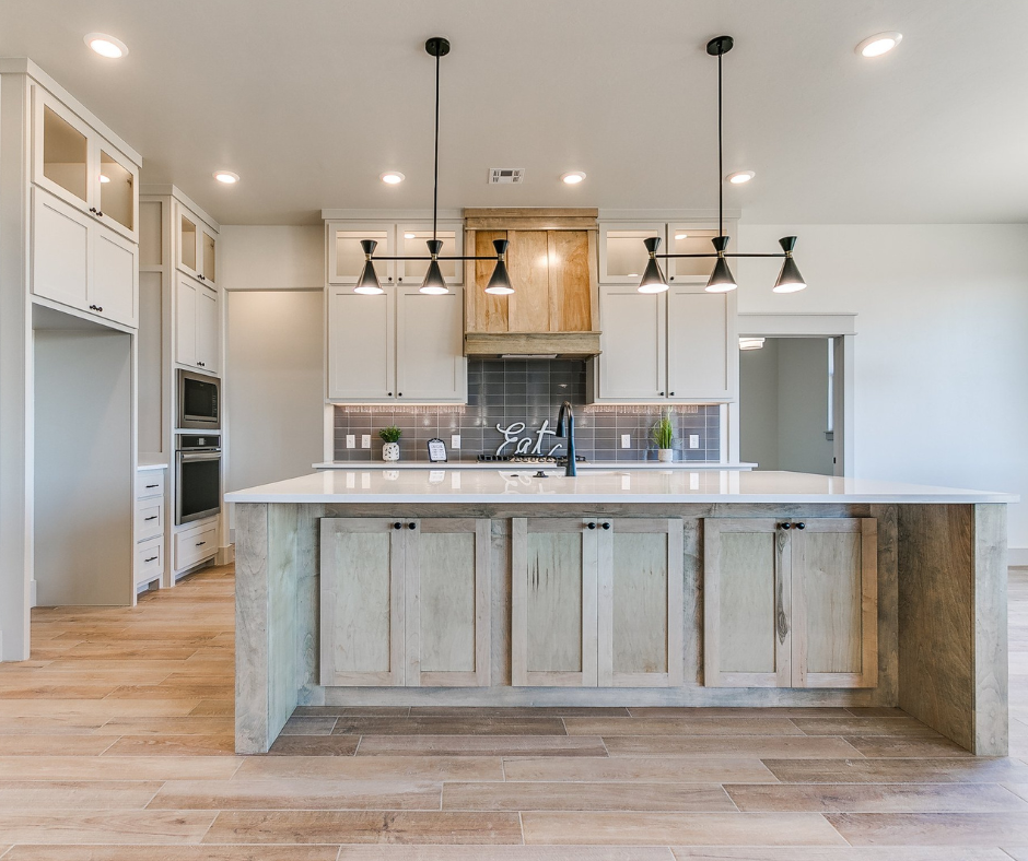A kitchen with a large island and white cabinets