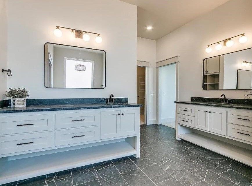 a bathroom with two sinks and a large mirror