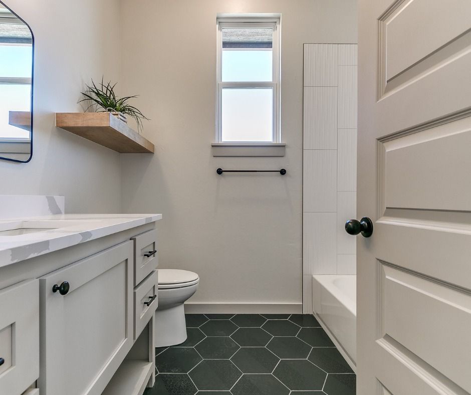 a bathroom with a toilet , sink , mirror and bathtub