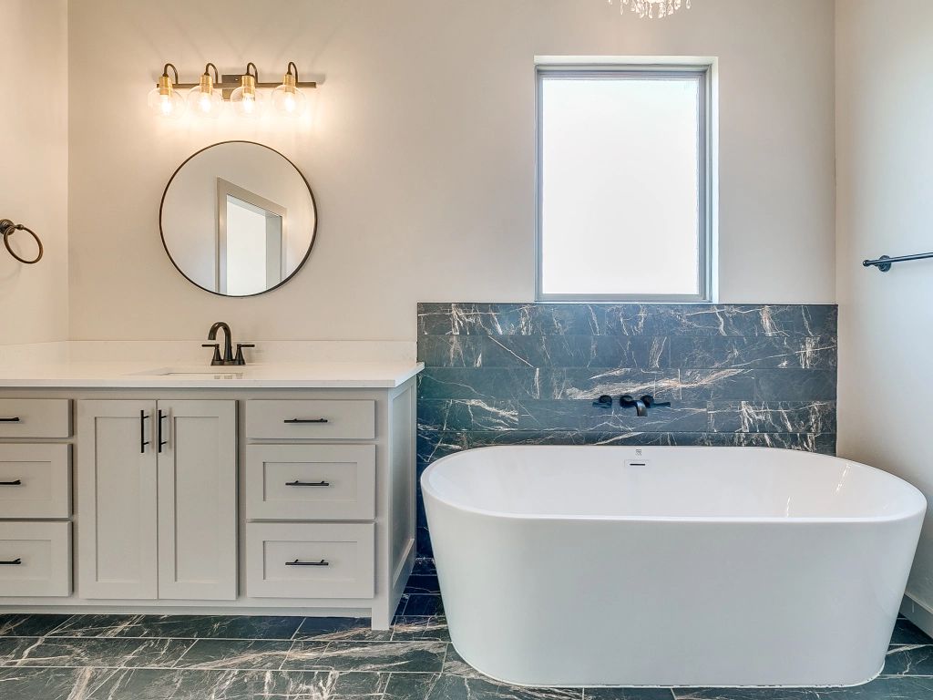 a bathroom with a bathtub , sink and mirror.