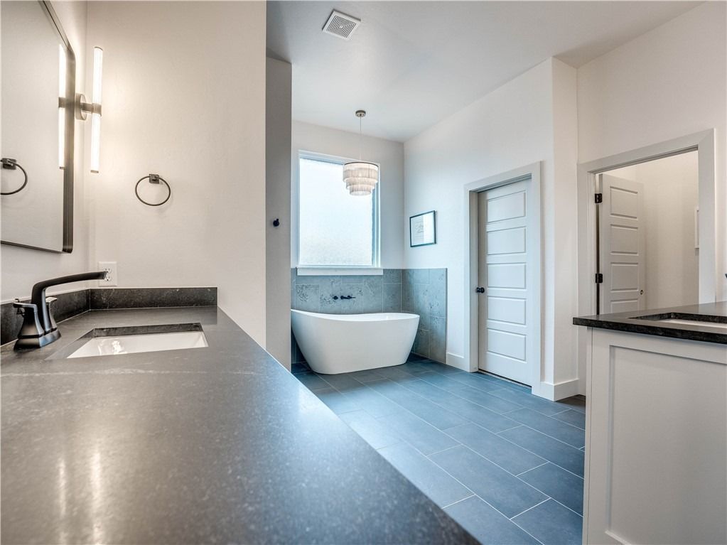 A bathroom with a bathtub , sink and mirror.