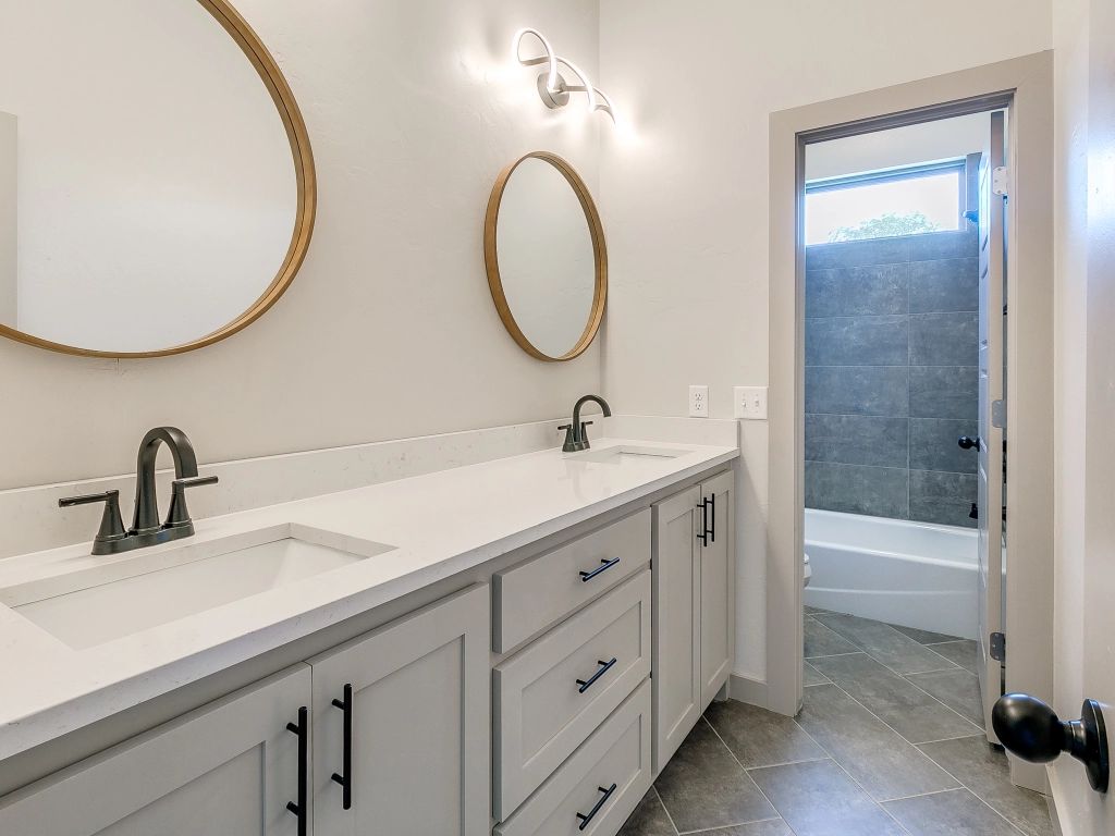 a bathroom with two sinks and two mirrors