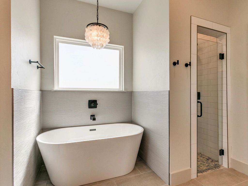 a bathroom with a tub , shower and window