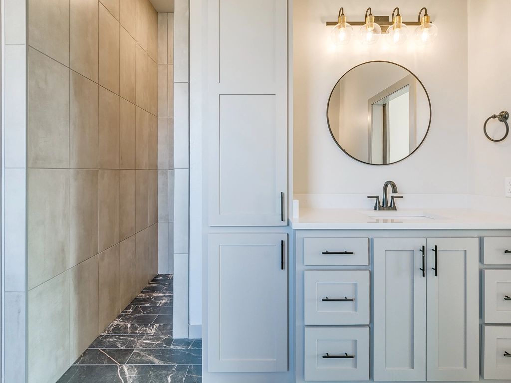 a bathroom with a sink , mirror and cabinets