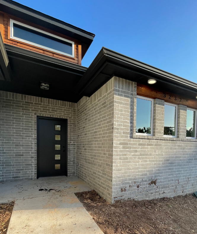A brick house with a black door and windows