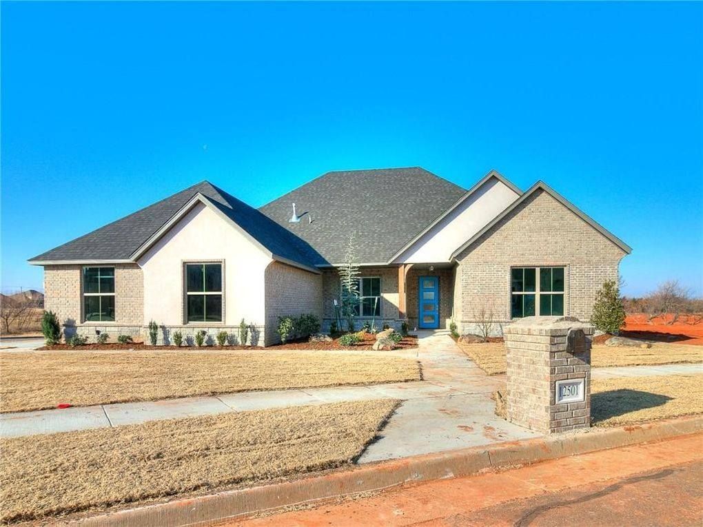 A large white house with a gray roof and a mailbox in front of it.