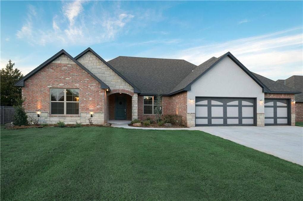 A large brick house with a black garage door