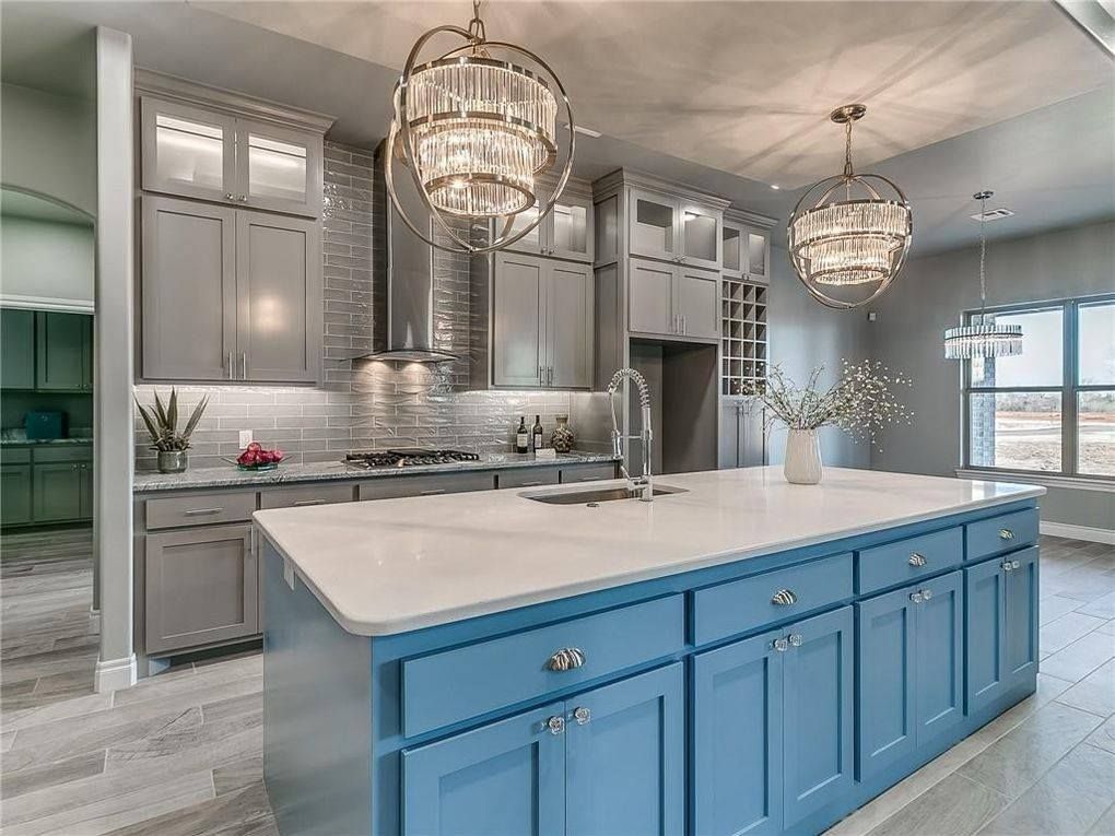 A kitchen with blue cabinets and a large island in the middle.