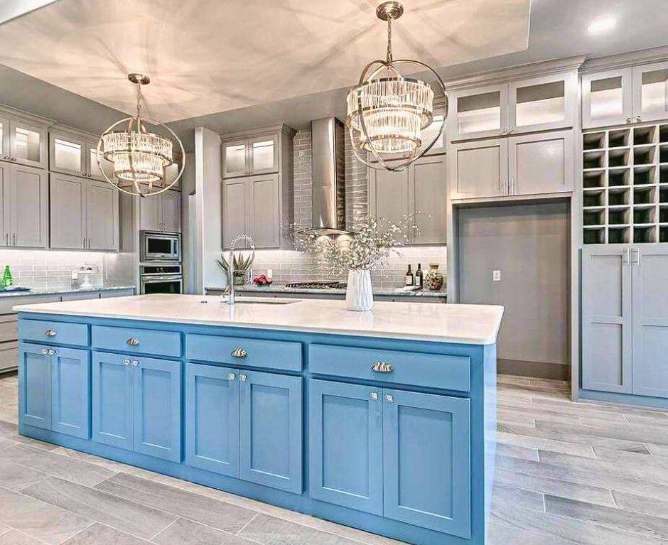 A kitchen with blue cabinets and a large island in the middle.