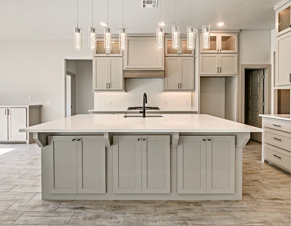 A kitchen with a large island and white cabinets