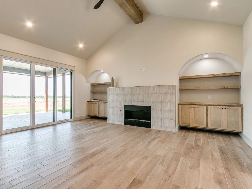 An empty living room with a fireplace and sliding glass doors.