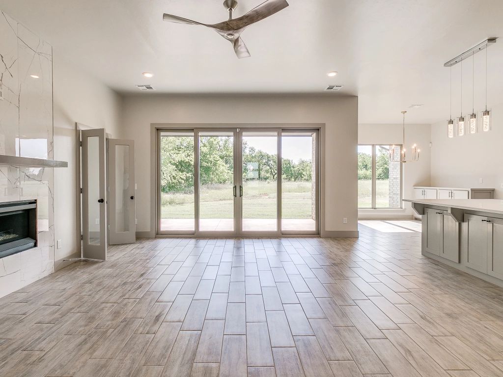An empty living room with hardwood floors and a ceiling fan.