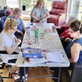 A group of people are sitting around a table playing bingo