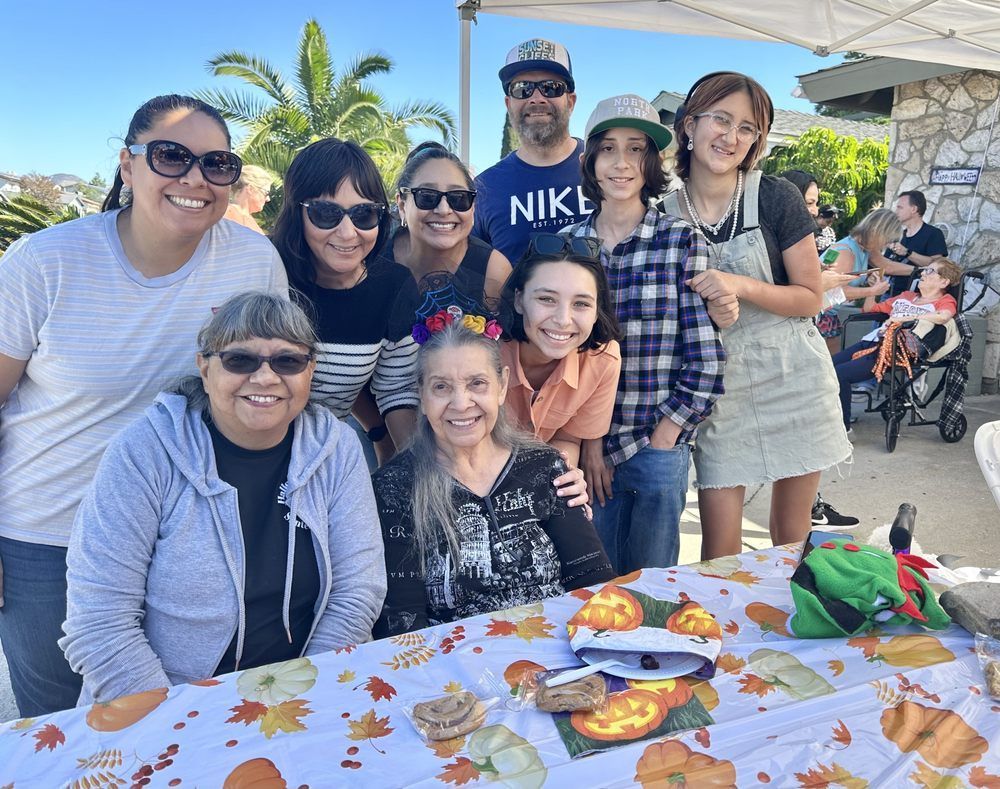 A group of people are posing for a picture while sitting at a table.