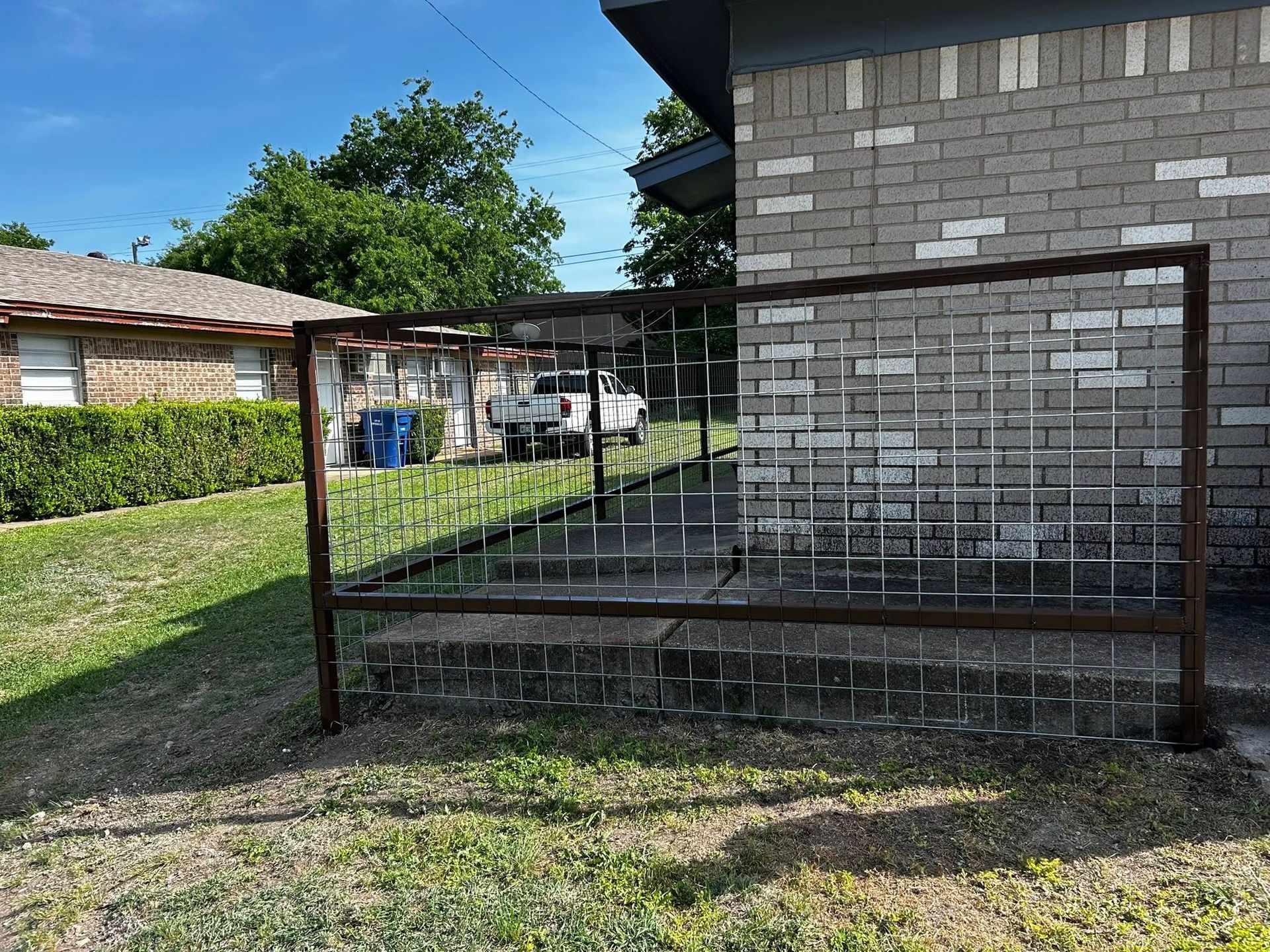 A metal fence is sitting in front of a brick house.