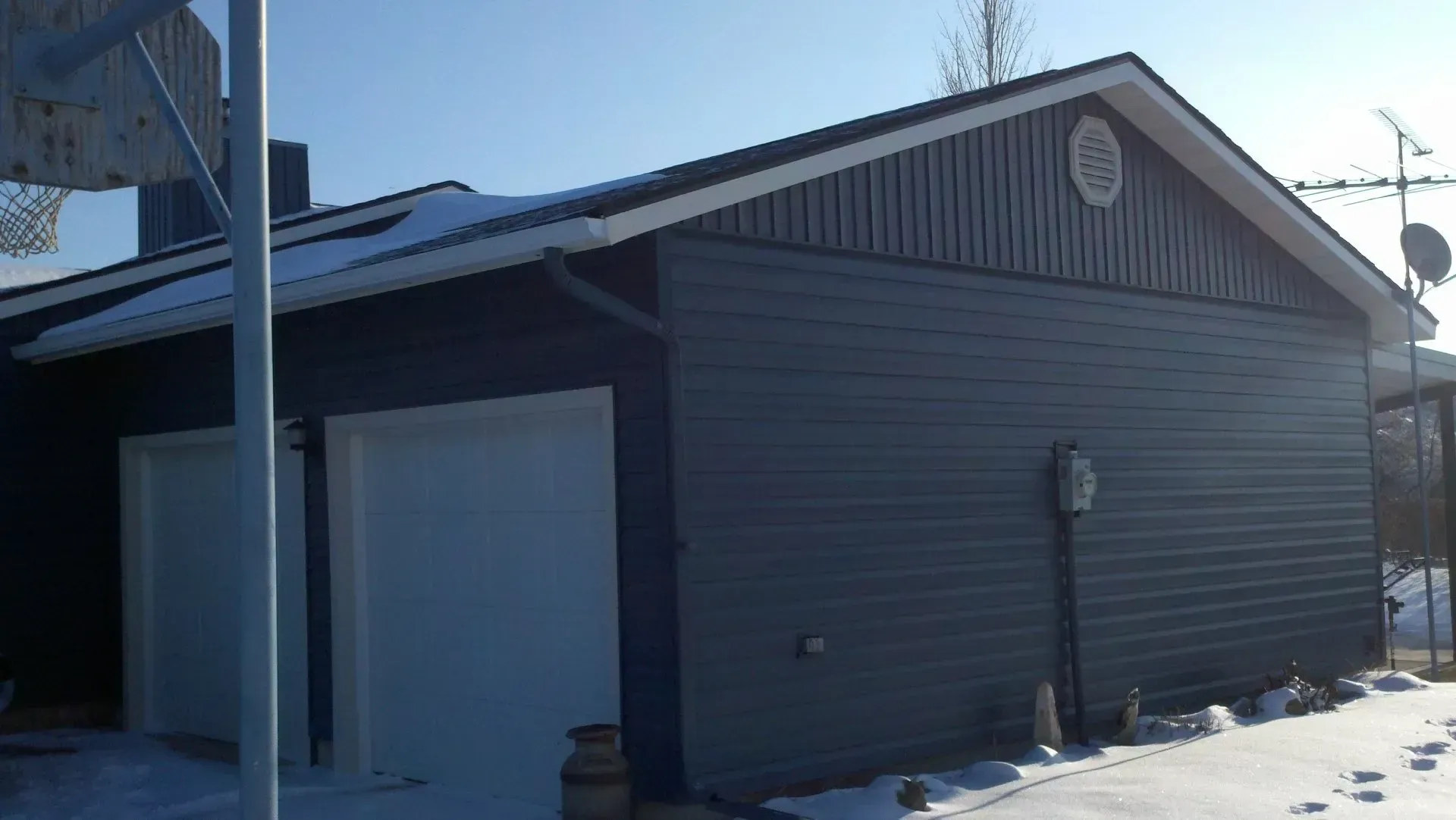A garage with a roof that is covered in snow.