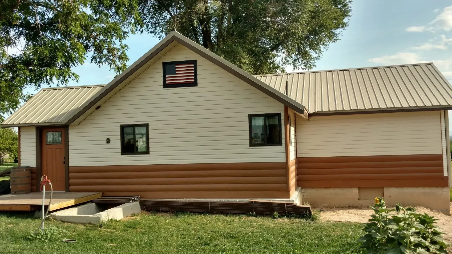 A house with a metal roof and an american flag on the top of it.