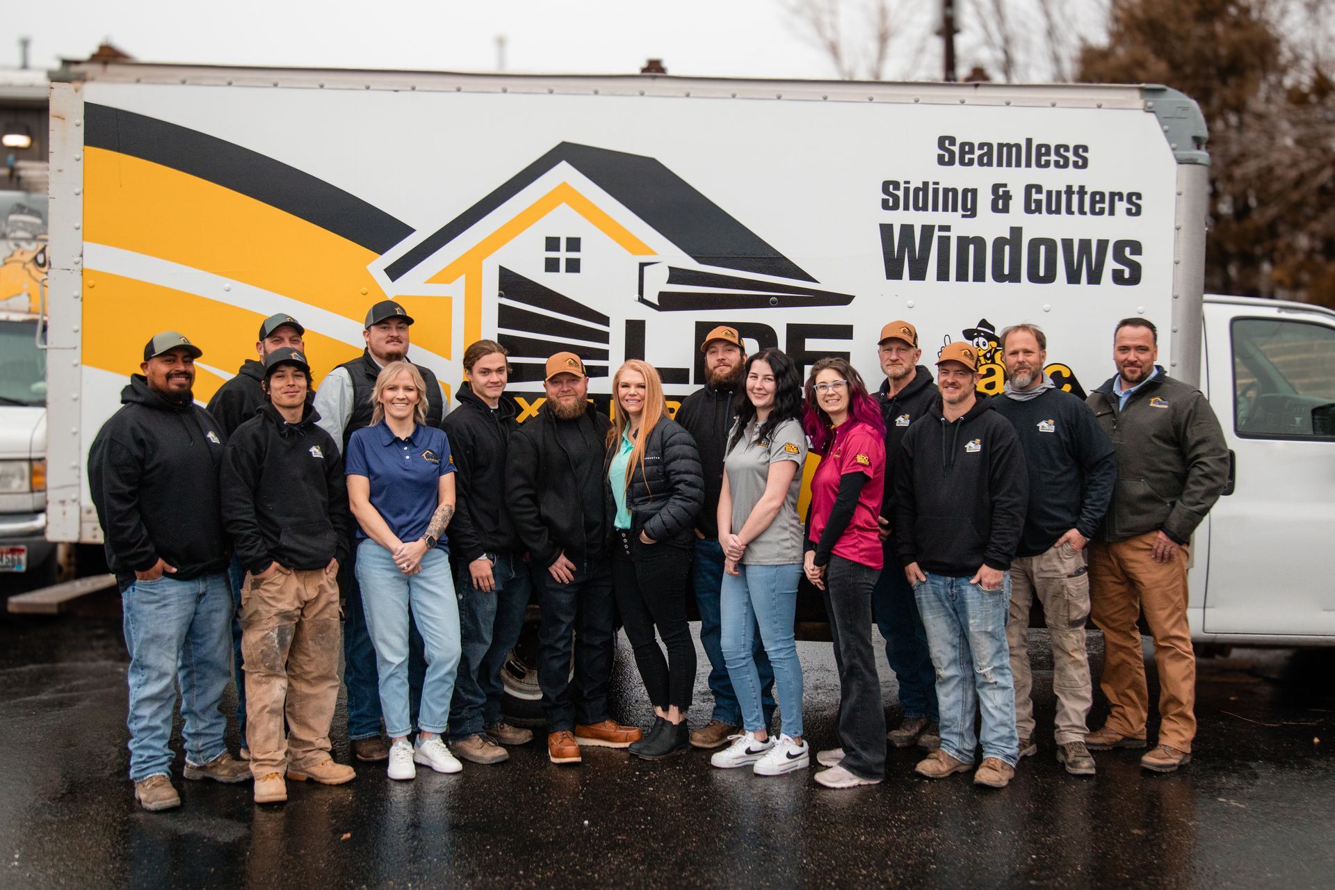 A group of people are posing for a picture in front of a abc seamless sign.