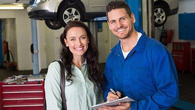 Automotive Discounts — Happy Customer Discusses Repairs with Auto Technician in Houston, TX