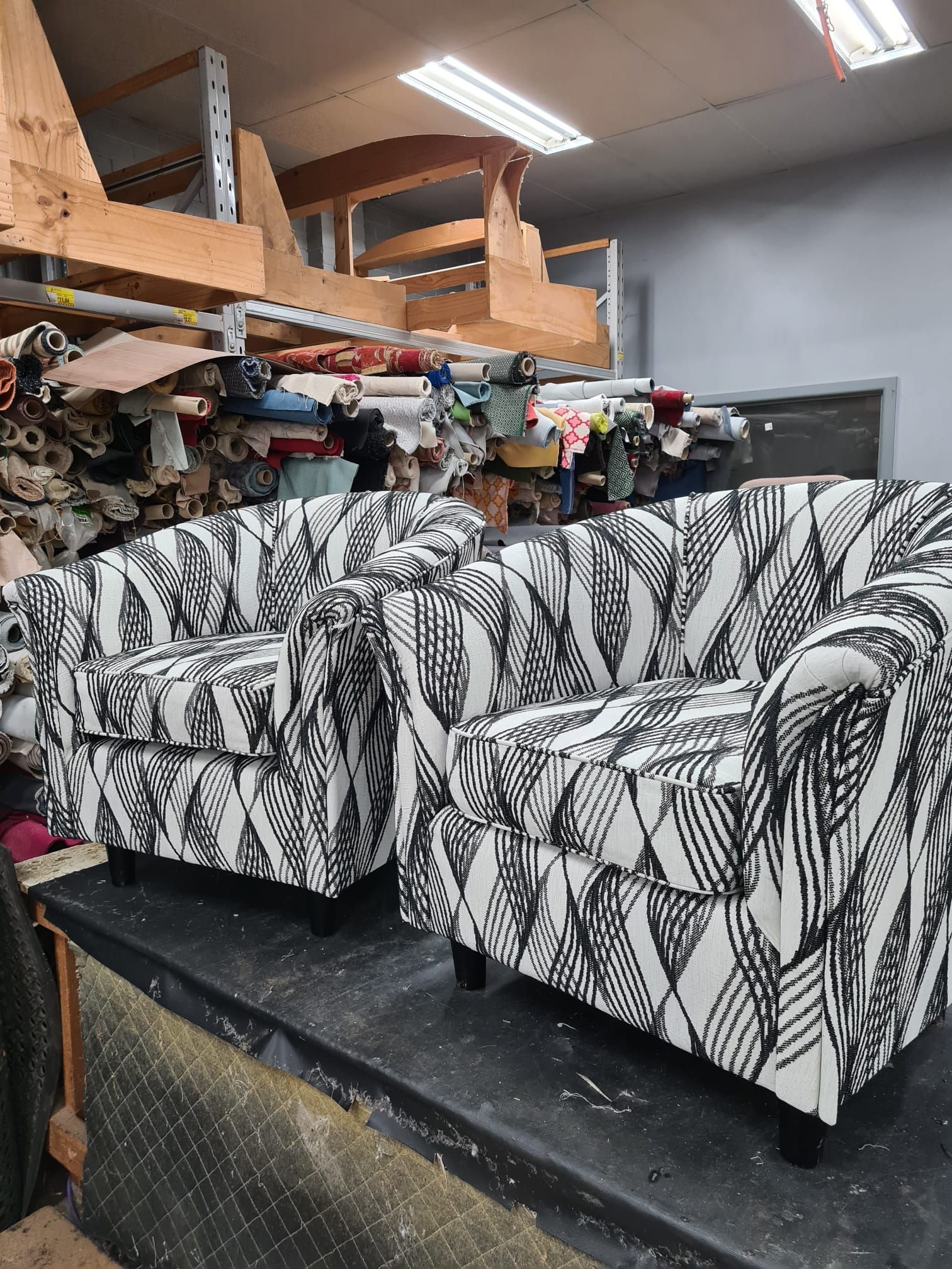 Two armchairs with a black and white leaf pattern in a fabric shop.