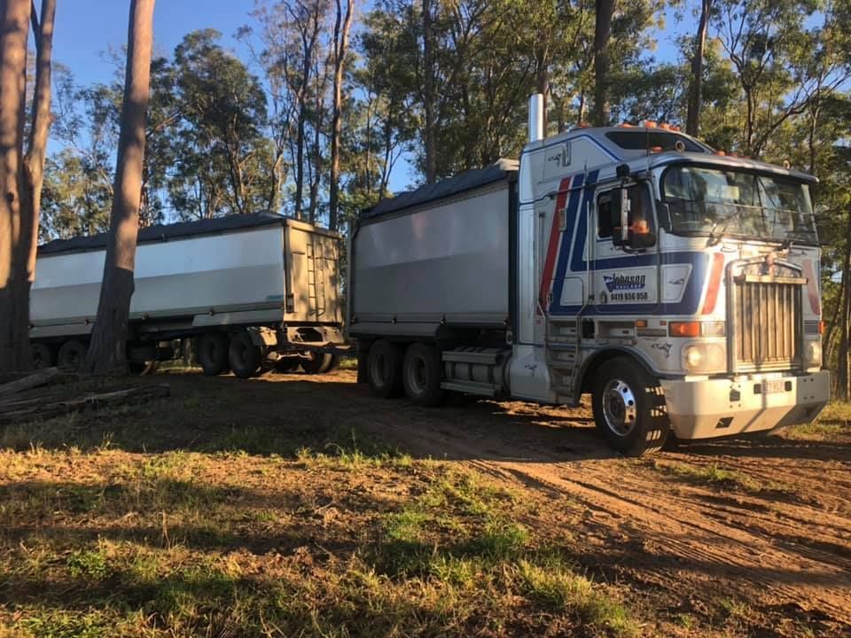 A Semi Truck is Parked in a Field With Trees in the Background — A2Z Property Services In Kybong, QLD