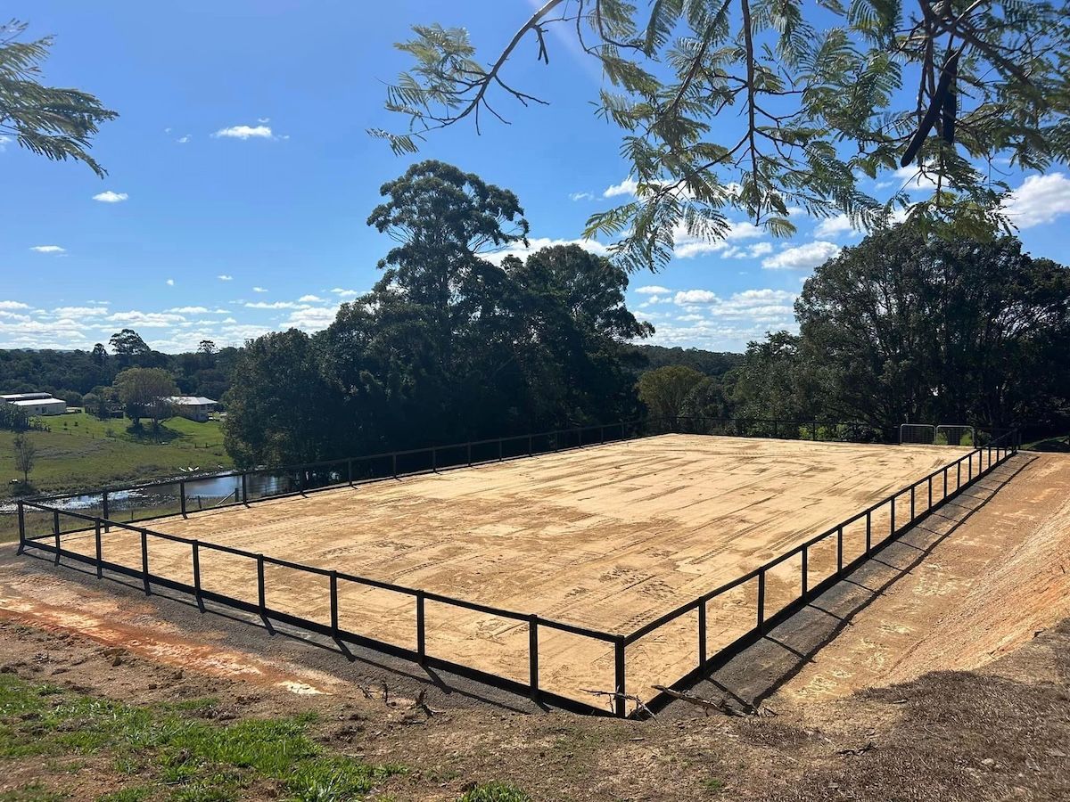 A Large Dirt Field With A Fence Around It And Trees In The Background — A2Z Property Services In Kybong, QLD