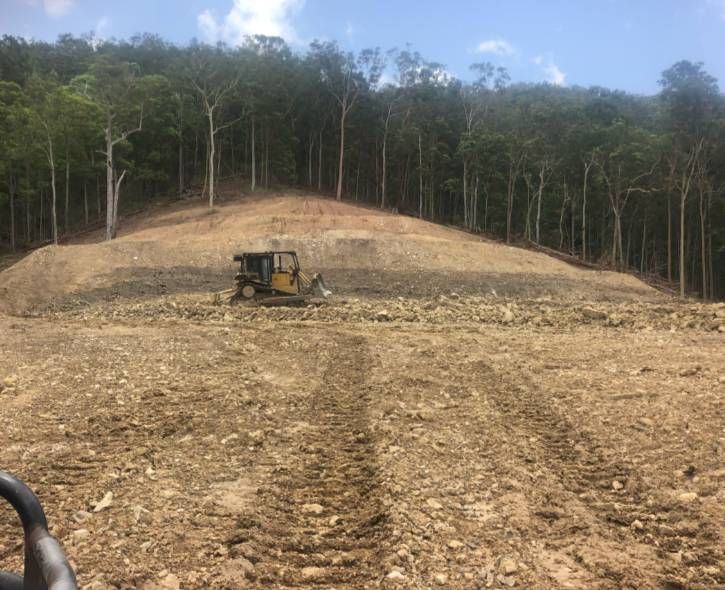 A Excavator On The Top Of A Dirt Hill — A2Z Property Services In Kybong, QLD