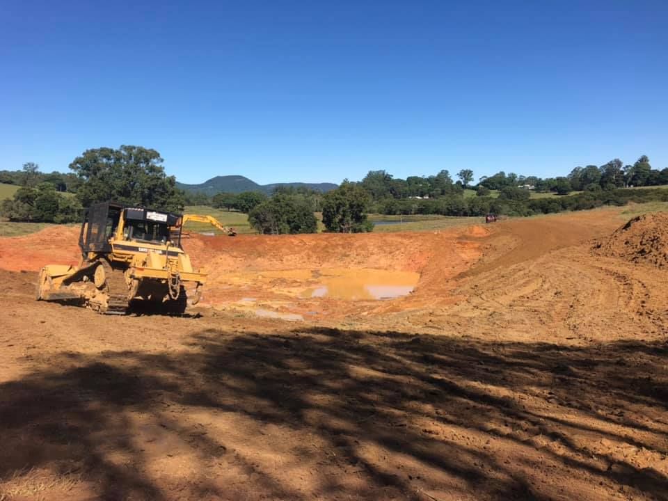 A Bulldozer Digging a New Pond — A2Z Property Services In Cooroy, QLD