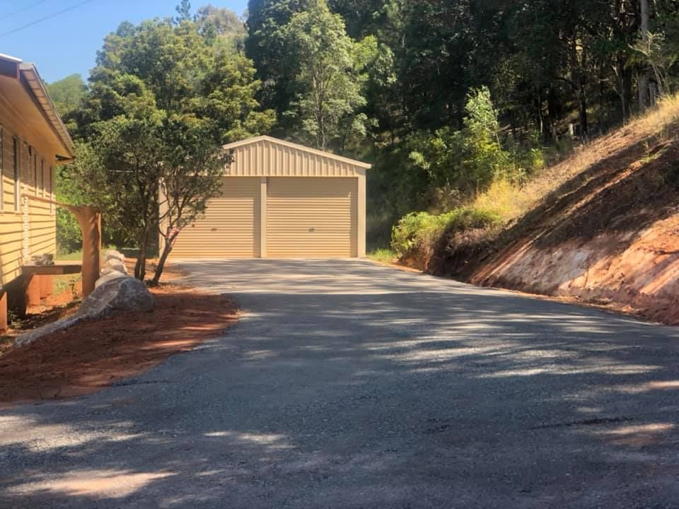 A Driveway Leads to A Two Door Garage in A Wooded Area — A2Z Property Services In Cooroy, QLD
