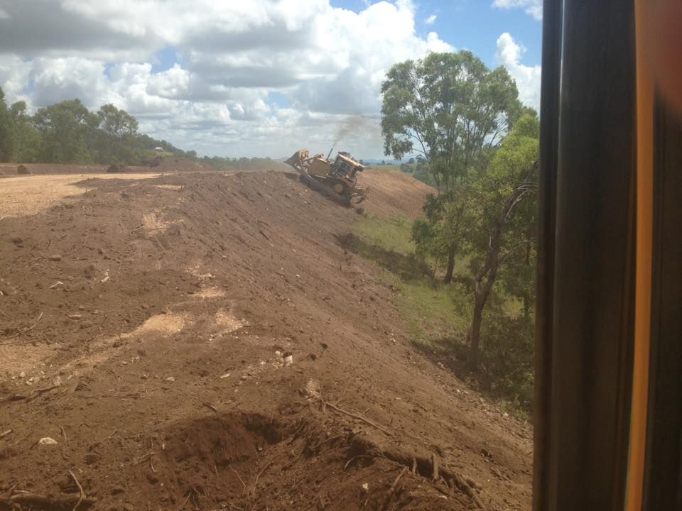 A Large Machine Works on An Earthen Hillside — A2Z Property Services In Cooroy, QLD