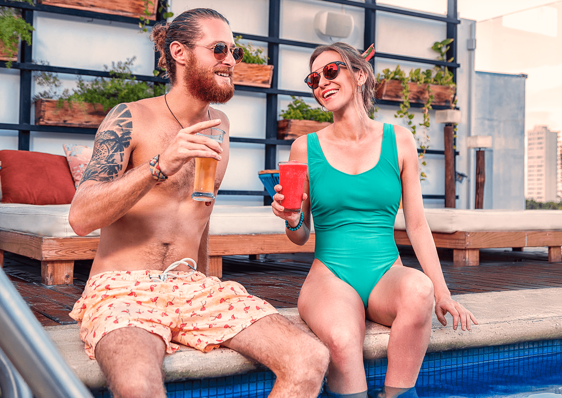 A man and a woman are sitting on the edge of a swimming pool.