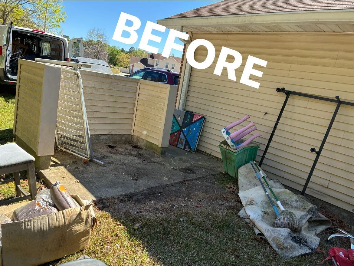 Cluttered outdoor area against a yellow-sided building, marked 