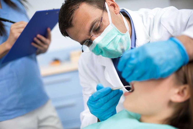 dentist performing procedure on female patient