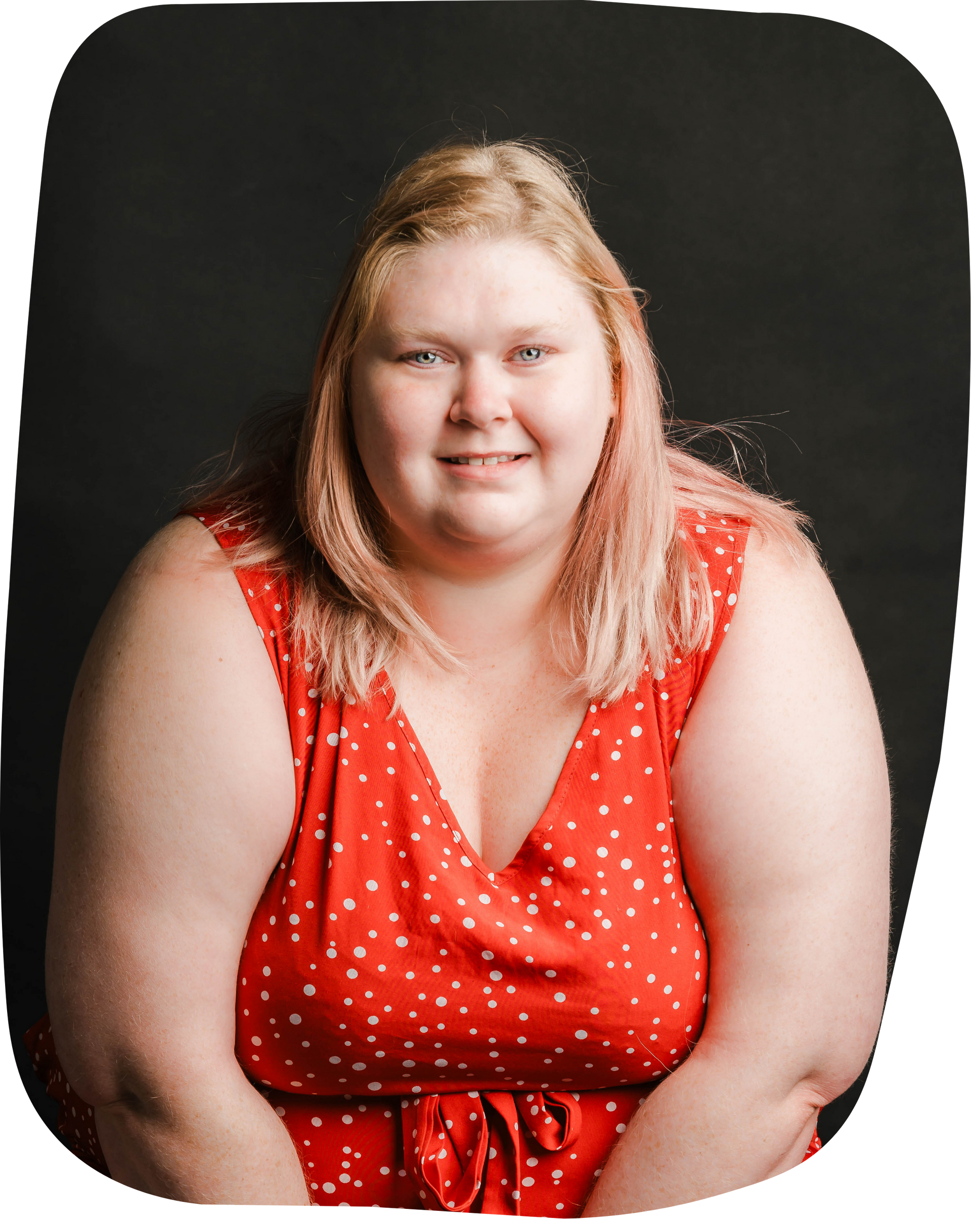 A woman in a red dress is smiling for the camera.