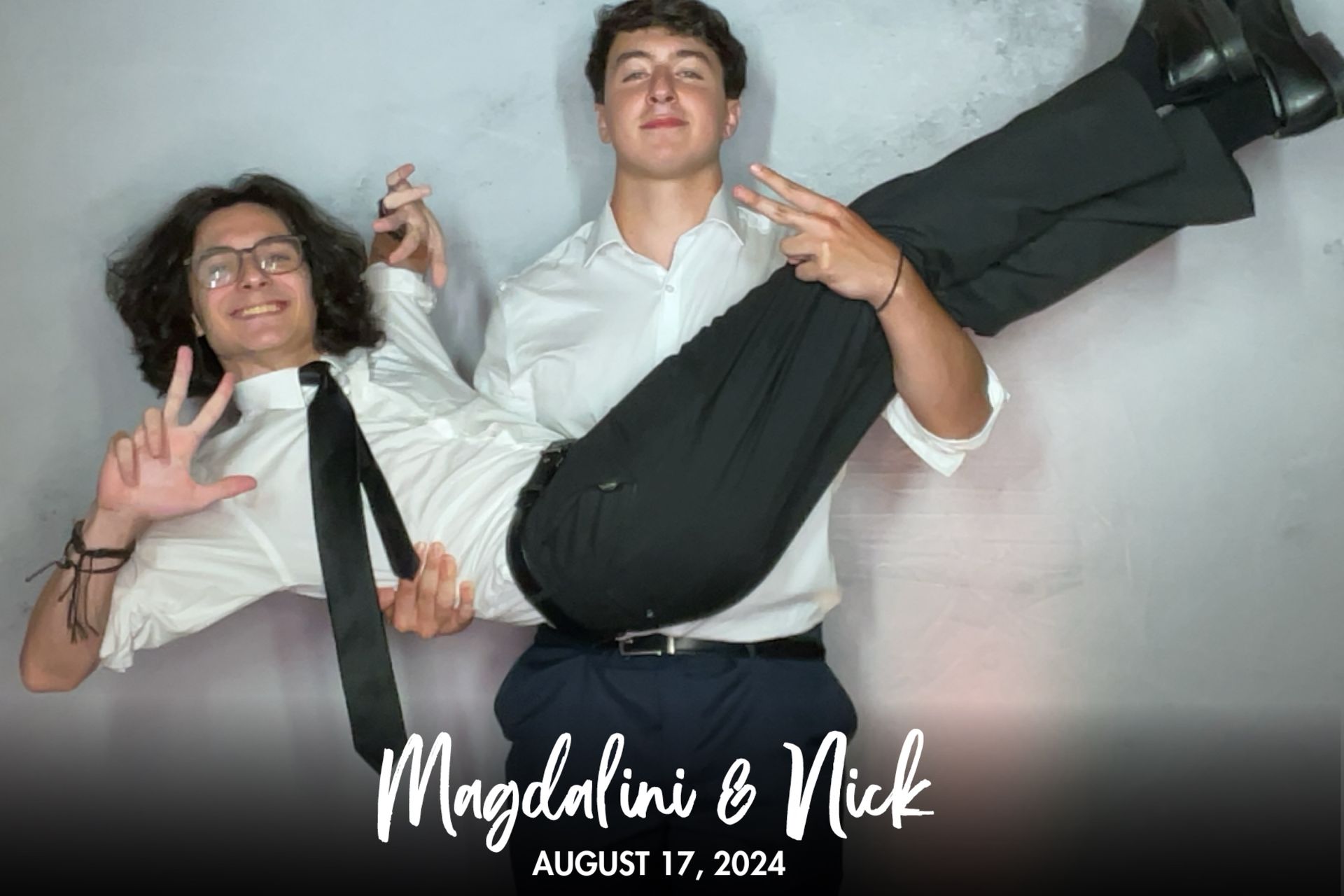 A man is holding another man in his arms in a photo booth.